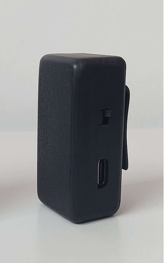 The Aligno device: a small matte-black clip-on unit with a USB-C charging port.