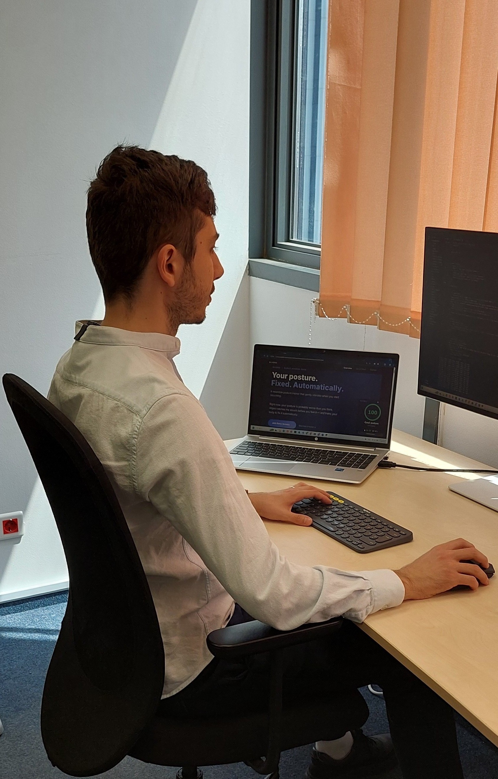 Person sitting with perfect posture while wearing the Aligno sensor